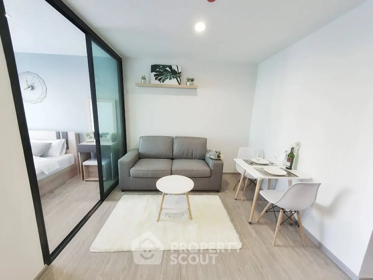 Modern living room with cozy sofa and dining area in open layout apartment.