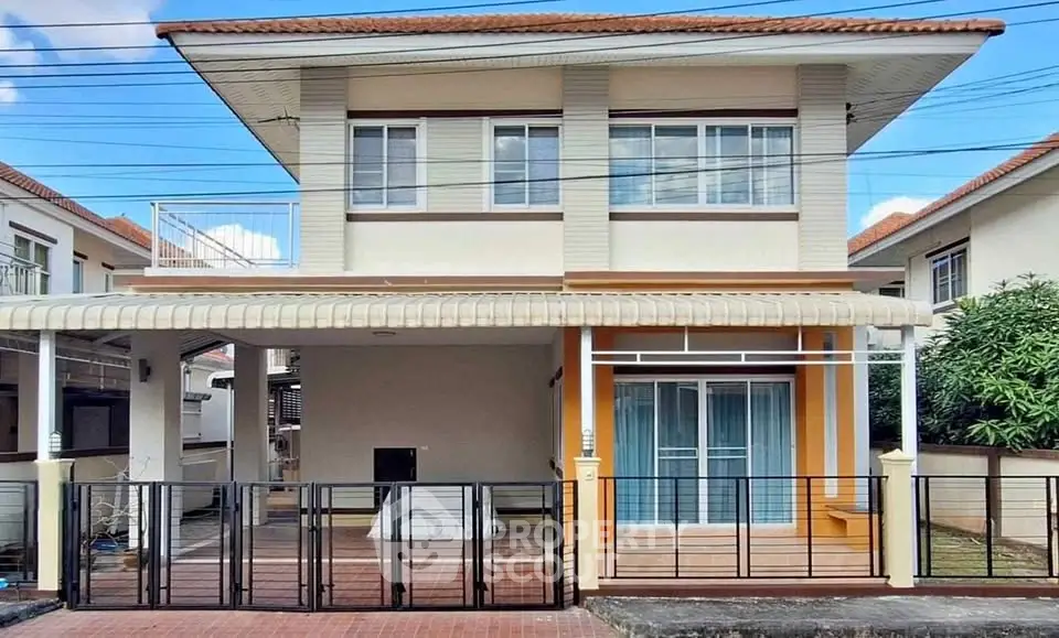 Charming two-story house with modern facade and gated entrance in a serene neighborhood.