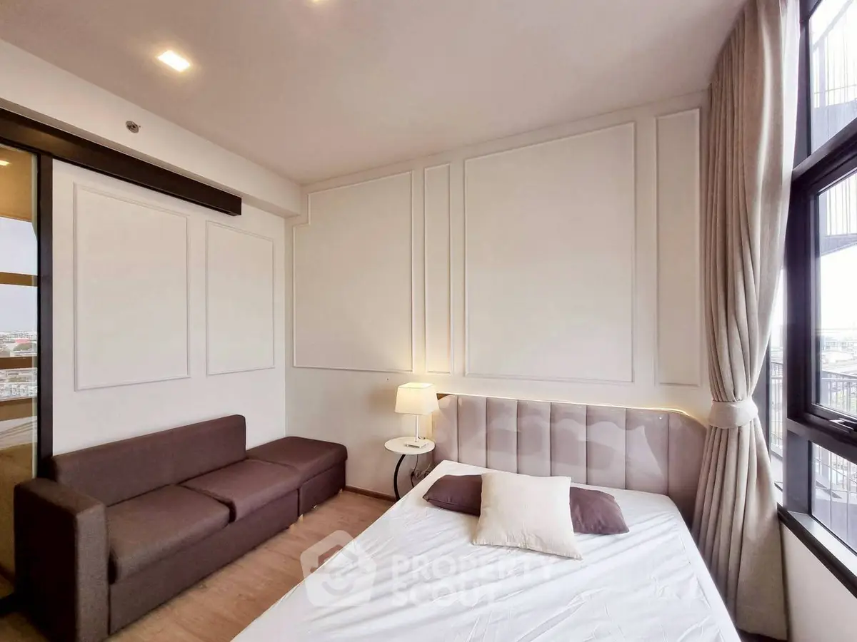 Modern bedroom with elegant decor and large windows offering natural light