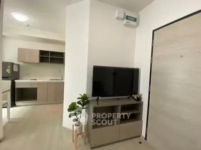 Modern apartment interior with open kitchen and stylish living area, featuring sleek furniture and natural light.