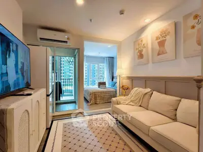 Charming living room with cozy sofa, stylish decor, and view into a bright bedroom with balcony access.