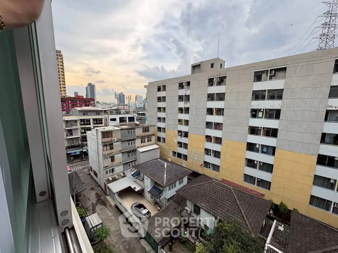 Urban apartment view showcasing cityscape and residential buildings.