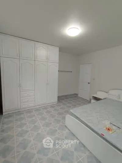 Spacious bedroom with built-in wardrobe and modern lighting