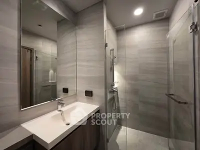 Modern bathroom with sleek design, glass shower, and elegant fixtures.