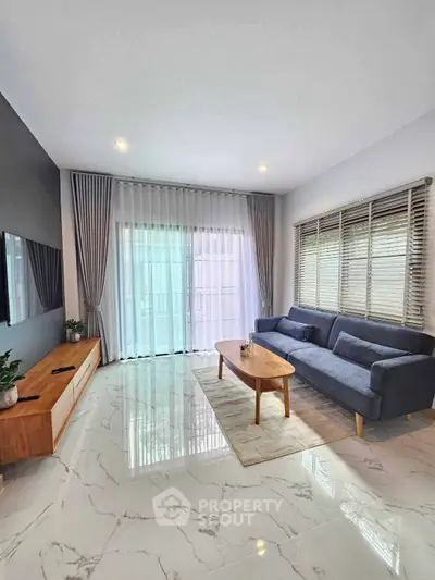 Modern living room with sleek furniture and large windows for natural light.