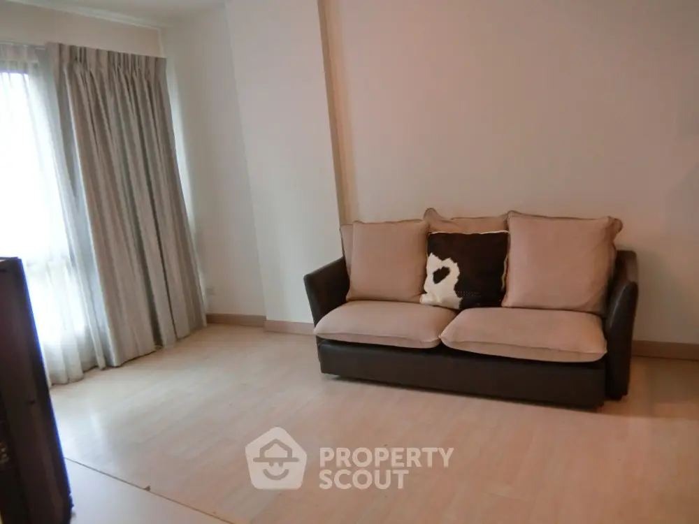 Cozy living room with a comfortable sofa and large window with curtains