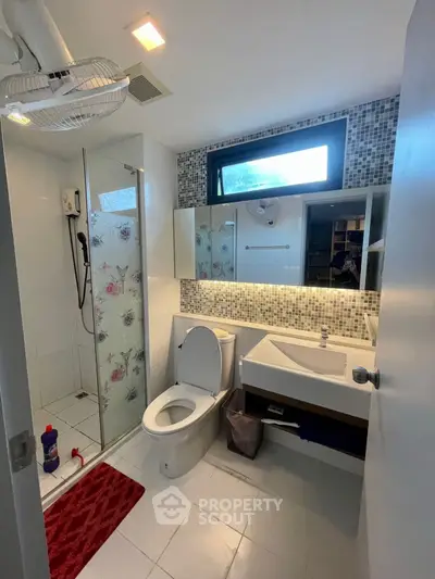 Modern bathroom with glass shower and stylish mosaic tiles