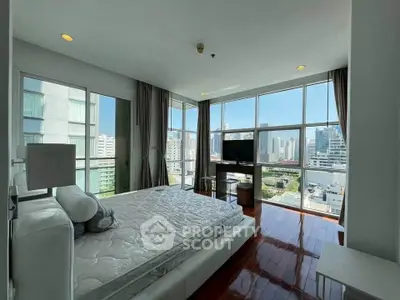 Luxurious bedroom with stunning city view and modern furnishings in high-rise apartment.