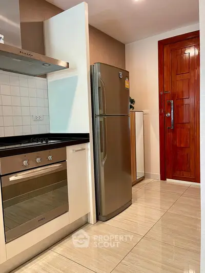 Modern kitchen with stainless steel appliances and wooden door