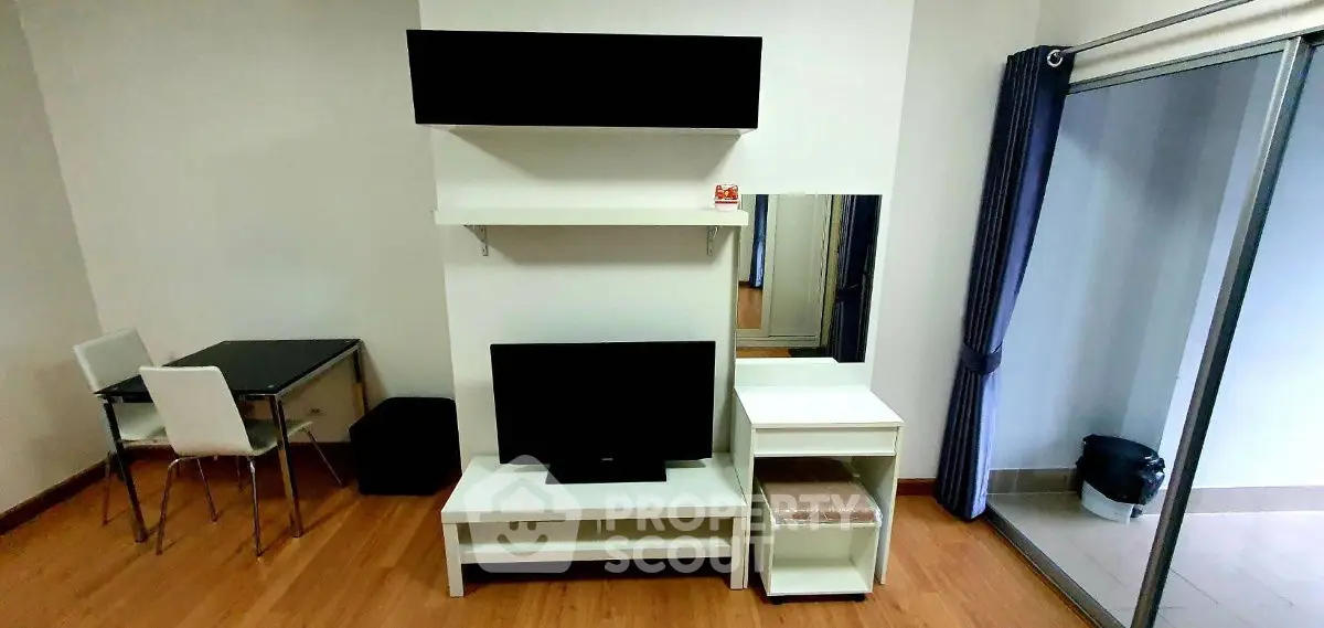 Modern living room with sleek furniture and balcony access, perfect for urban living.