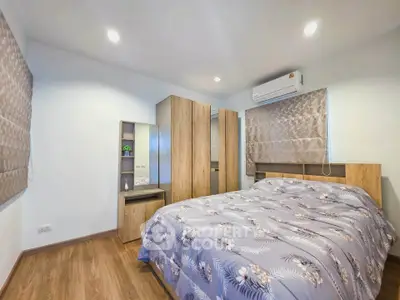 Cozy bedroom with modern wooden furniture and air conditioning, perfect for relaxation.