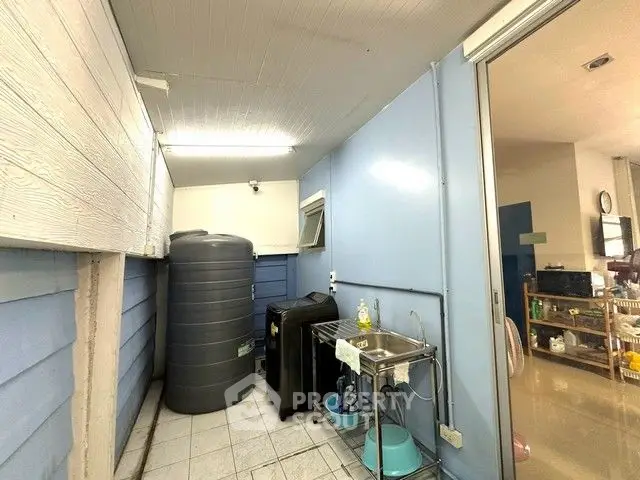 Utility area with water tank and washing machine in a modern home