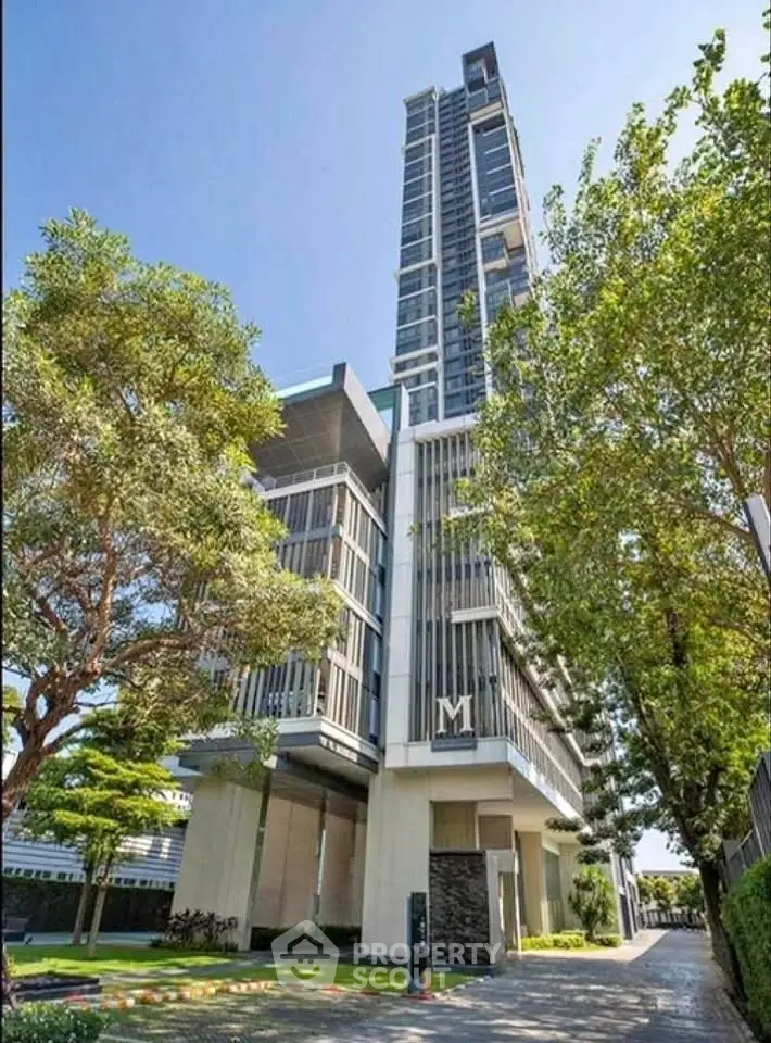Stunning modern high-rise building with lush greenery and sleek architectural design.