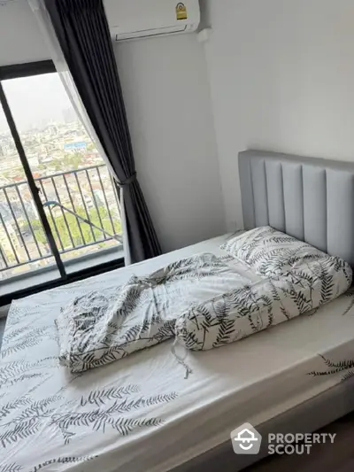 Modern bedroom with city view and stylish bedding in high-rise apartment