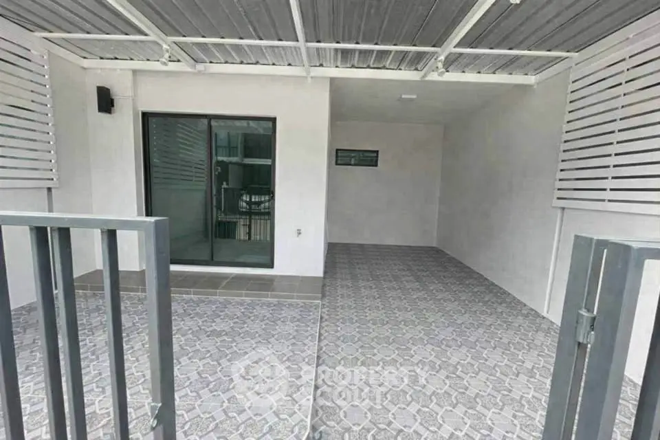 Modern covered patio with stylish tile flooring and sliding glass door entry.