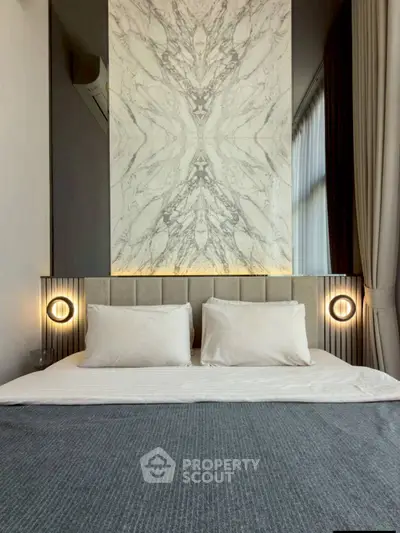 Luxurious bedroom with elegant marble accent wall and modern lighting