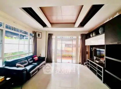 Spacious modern living room with sleek black furniture and large windows