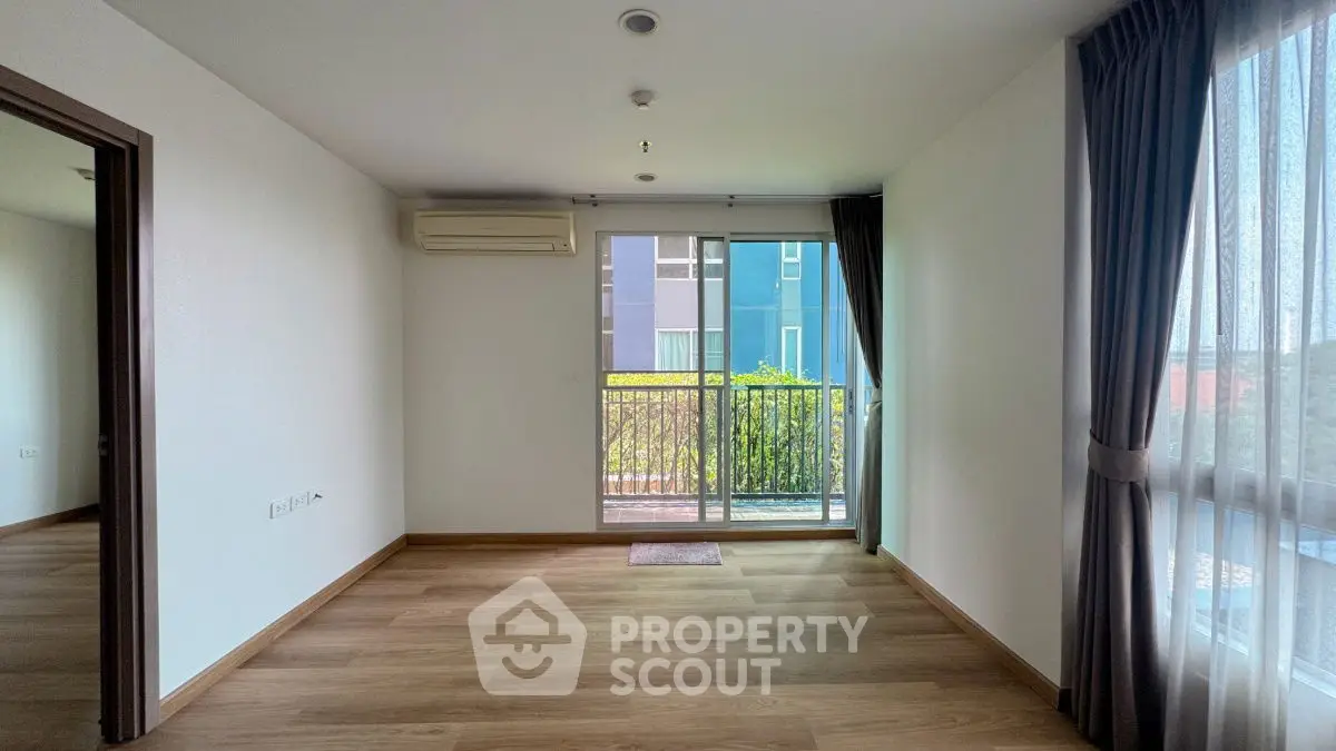 Spacious empty living room with balcony access and large windows