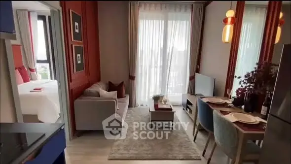 Modern living room with elegant decor and open layout, featuring a cozy sofa and dining area.