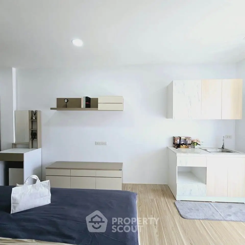 Modern studio apartment with sleek kitchen and cozy living area, perfect for urban living.