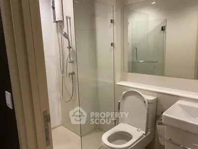 Modern bathroom with glass shower and sleek fixtures in a contemporary apartment.