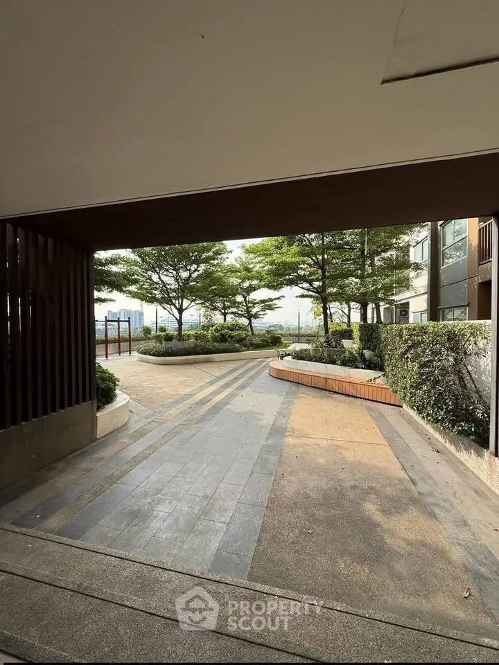 Modern building entrance with landscaped garden and paved walkway
