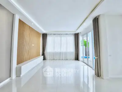 Spacious modern living room with large windows and elegant curtains, perfect for natural light lovers.