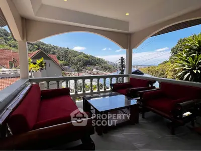 Stunning balcony with ocean view and elegant seating in a tropical setting.