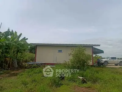 Charming rural property with lush greenery and a compact building, ideal for serene living.