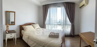 Spacious bedroom with large windows offering ample natural light, complete with elegant furnishings and a serene ambiance for restful living.