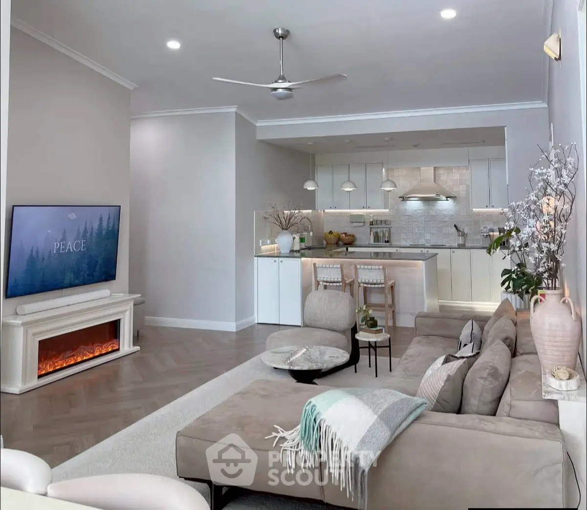 Modern living room with cozy sectional sofa, stylish kitchen, and elegant decor in open-concept layout.