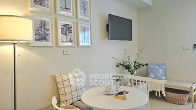 Cozy living room with modern decor, wall art, and a mounted TV, perfect for relaxation.