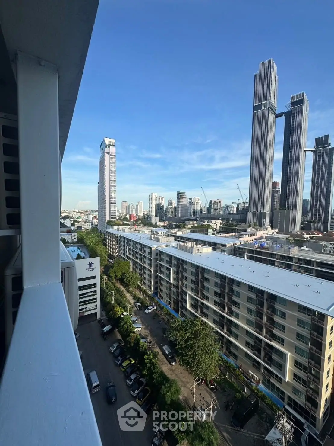 Stunning cityscape view from a high-rise balcony overlooking modern skyscrapers and urban landscape.