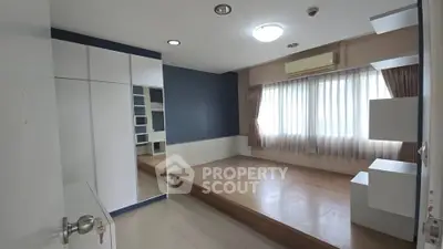 Spacious bedroom with elevated wooden platform and built-in wardrobe