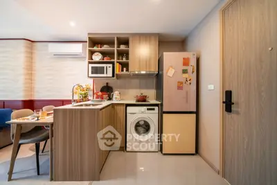 Modern kitchen with washing machine and fridge in cozy apartment