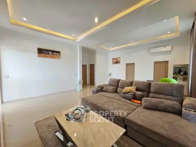 Spacious modern living room with plush sectional sofa and elegant recessed lighting.