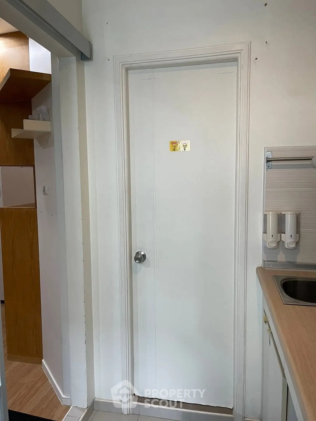 Compact kitchen area with white door and modern fixtures in cozy apartment