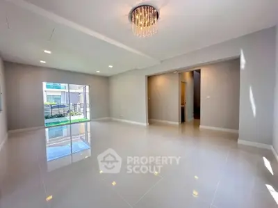 Spacious modern living room with glossy tile flooring and elegant chandelier