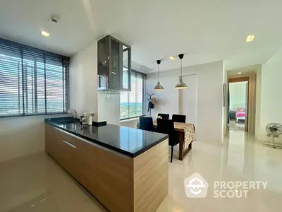 Modern open-layout kitchen with dining area and panoramic window views.