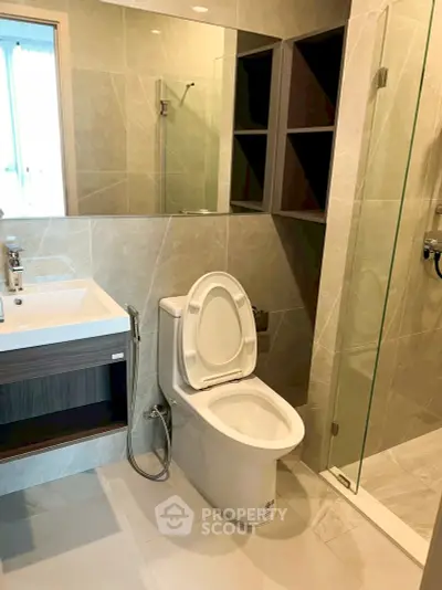 Modern bathroom with glass shower and sleek fixtures in a contemporary apartment.