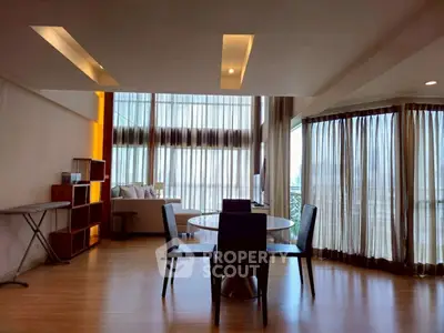 Spacious modern living room with floor-to-ceiling windows and elegant dining area.