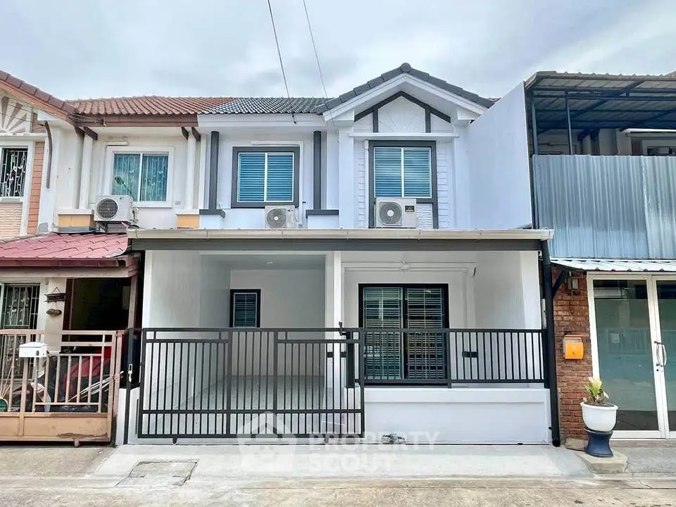 Charming townhouse with modern facade and gated entrance in a serene neighborhood.