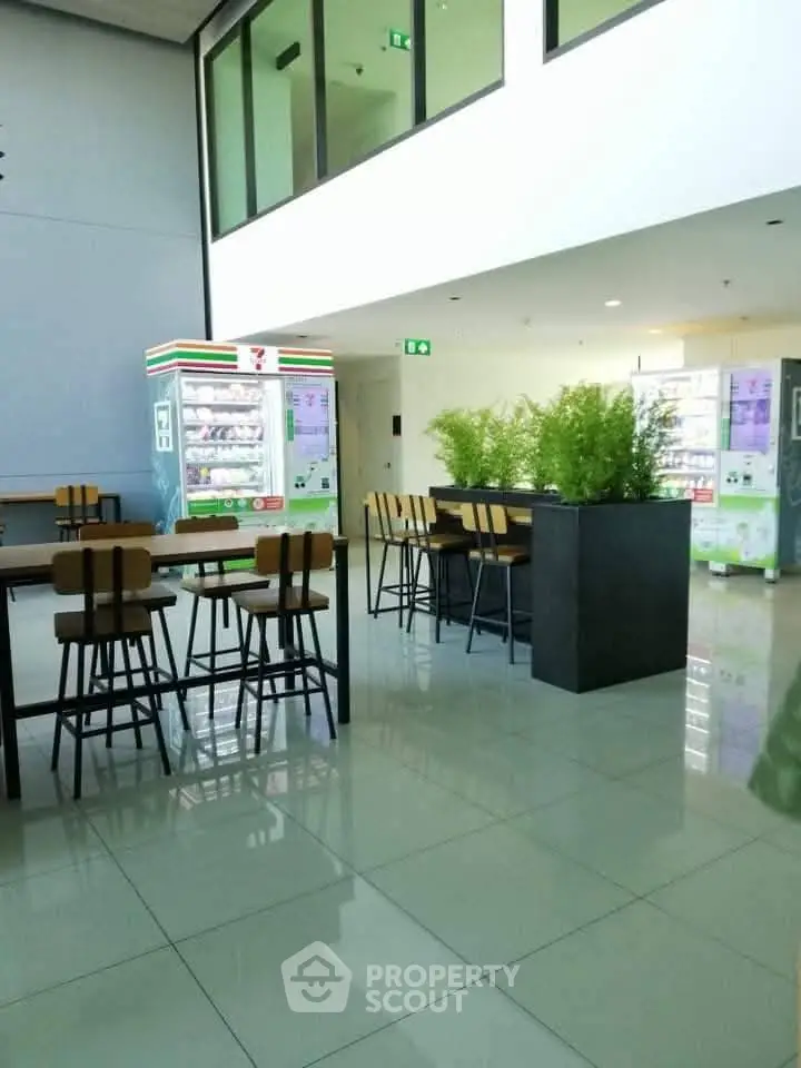 Modern common area with vending machines and seating in a contemporary building.