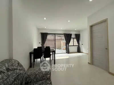 Spacious modern living room with dining area and large windows for natural light.