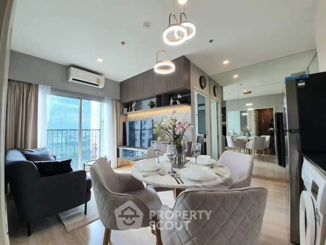 Modern living room with dining area, featuring elegant furniture and large windows.