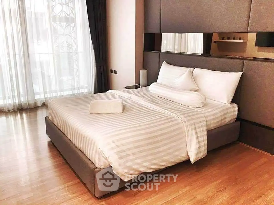 Elegant bedroom with modern design and large windows for natural light.