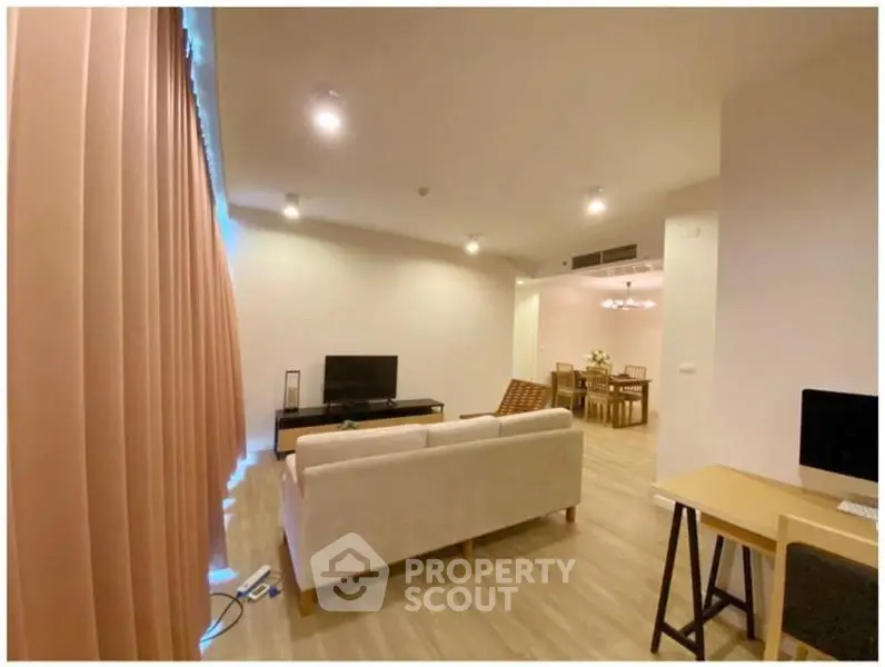Spacious living room with modern decor and open dining area