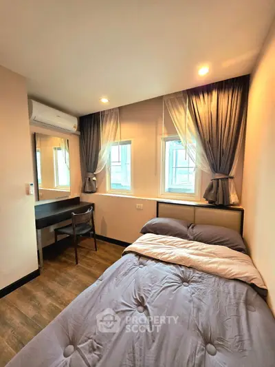 Cozy bedroom with modern decor, featuring a comfortable bed, stylish curtains, and a functional workspace.
