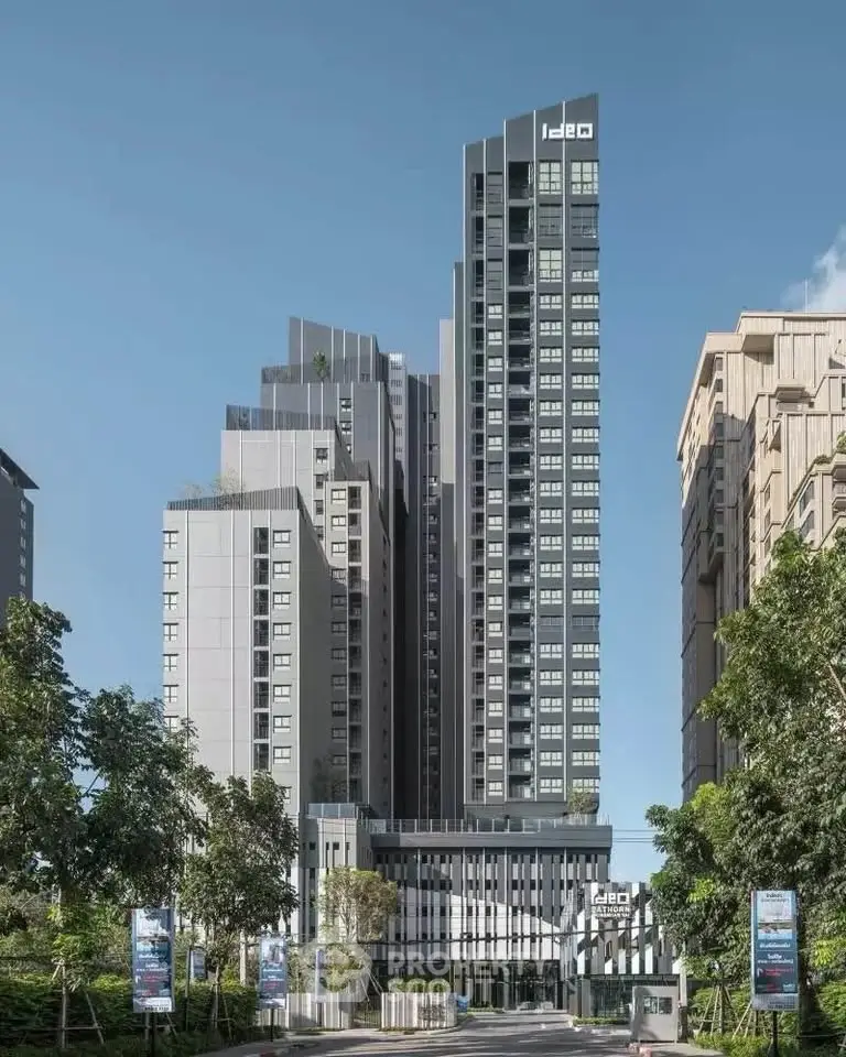 Modern high-rise building with sleek design and lush surroundings.