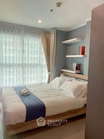 Modern bedroom with large windows and stylish decor in a high-rise apartment.